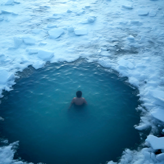 This image showcases Cold Plunge, a practice of cold water therapy. It features a man standing in a pool filled with icy water up to his waist, wearing swimwear. The image represents the refreshing and energizing effects of this cold immersion.